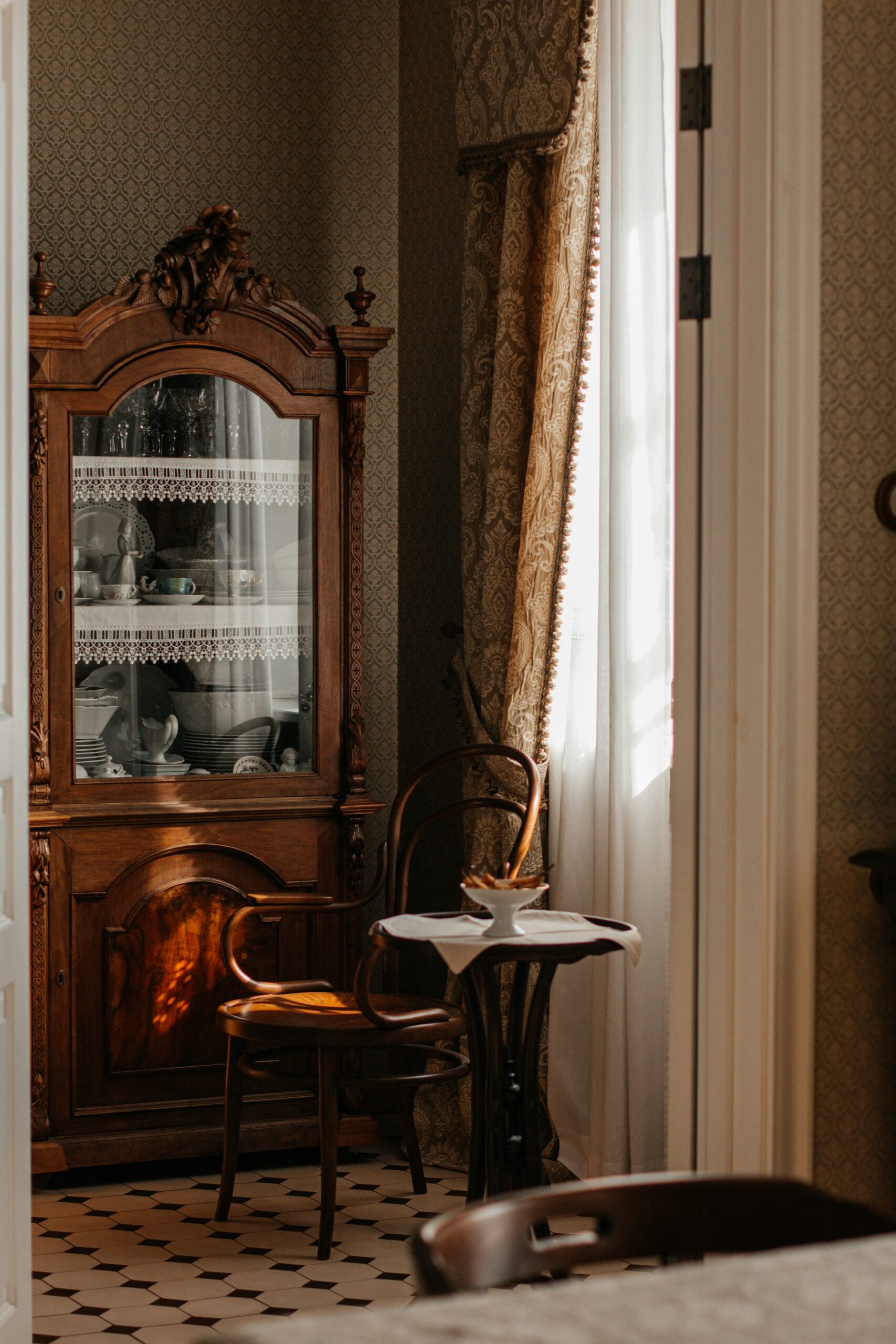 Meuble ancien, chaise et petite table dans un intérieur lumineux