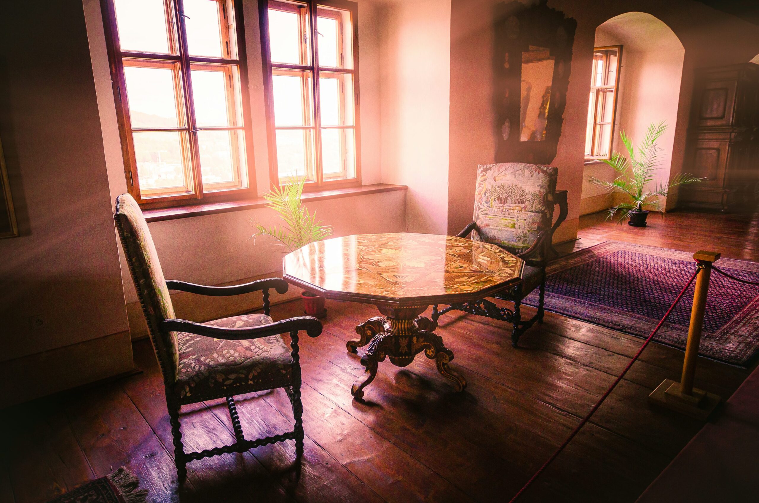 Chaises et table anciennes dans un salon baigné de lumière