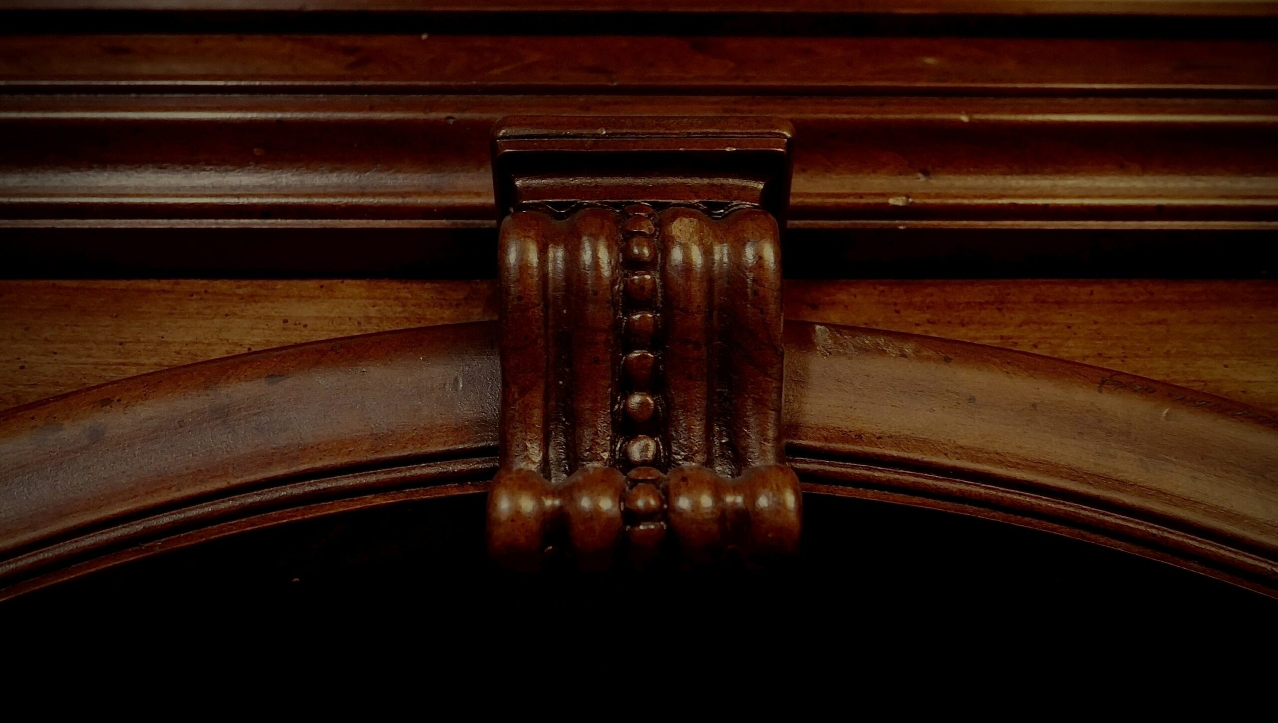 Détail de sculpture sur un meuble ancien en bois sombre